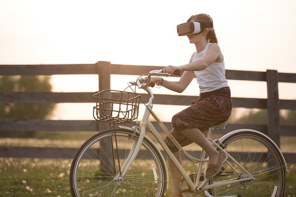 VRを装着した状態で自転車を漕ぐ女性